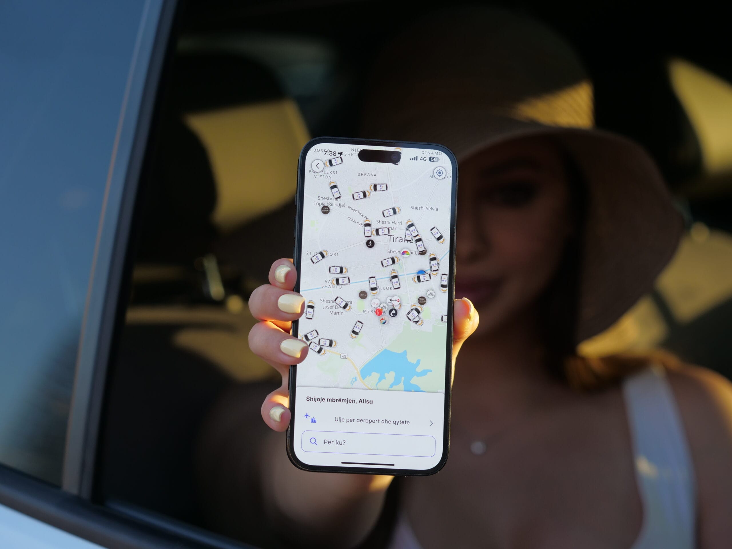 Patoko App being held by someone sitting in a car